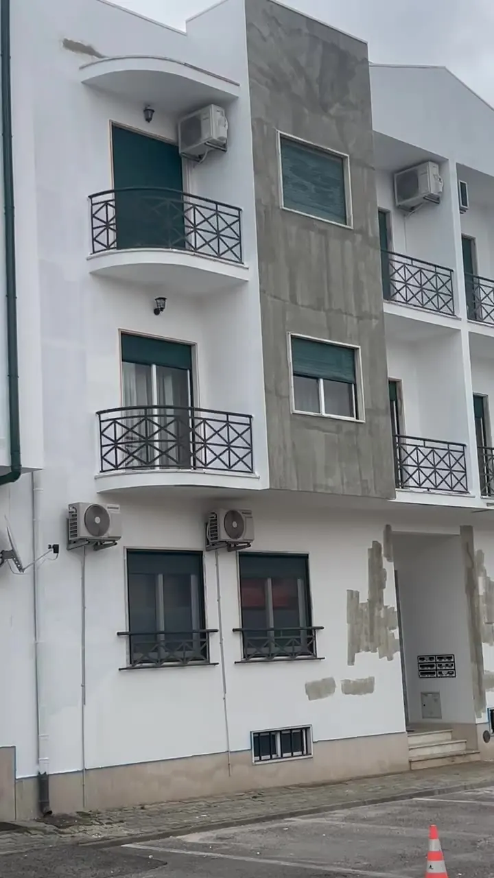 Fachada de edifício em fase de reparação e pintura, obra em curso